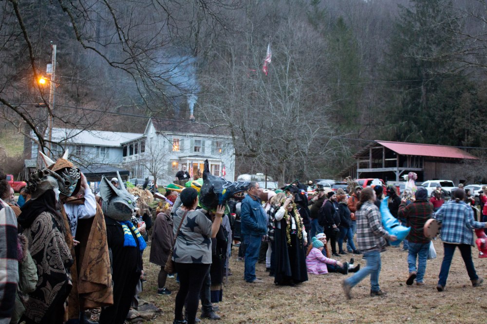A crowd of people stand outside during the mask contest.