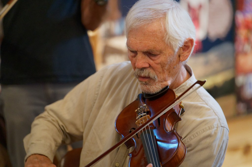An older man plays fiddle.