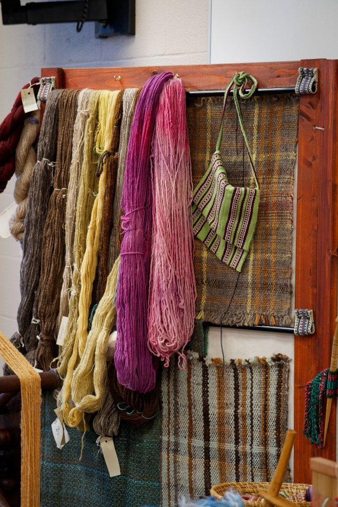 A display of naturally dyed yarn and woven items.