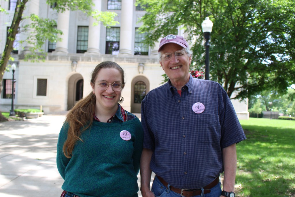 A man and a woman standing beside each other outside smiling for the picture.